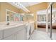 Bathroom with double sinks, large mirror, and doorway to bedroom at 4374 Mirabella Cir, Bradenton, FL 34210