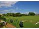 Golf driving range with Callaway bags and a view of a green field and trees under a blue sky at 4374 Mirabella Cir, Bradenton, FL 34210