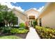Inviting front entrance with lush landscaping, a walkway, and a welcoming double-door entry at 4374 Mirabella Cir, Bradenton, FL 34210