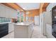 Efficient kitchen with white cabinets, black appliances, and tile floors; perfect for meal preparation at 4374 Mirabella Cir, Bradenton, FL 34210