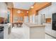 Open kitchen with large island, white cabinets, black appliances, dining area, and tile flooring at 4374 Mirabella Cir, Bradenton, FL 34210