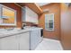 Bright laundry room featuring white appliances, cabinet storage, and a sink at 4374 Mirabella Cir, Bradenton, FL 34210