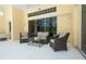 Covered patio with modern outdoor furniture and sliding glass doors leading inside at 4374 Mirabella Cir, Bradenton, FL 34210