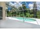 Screened pool with handrail, surrounded by a white concrete deck and lush landscaping at 4374 Mirabella Cir, Bradenton, FL 34210