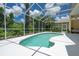 A kidney-shaped pool enclosed in a white screened enclosure with outdoor seating area at 4374 Mirabella Cir, Bradenton, FL 34210