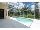 Screened pool with white concrete patio and lush foliage surrounding the space at 4374 Mirabella Cir, Bradenton, FL 34210