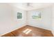 Bedroom features hardwood floors, neutral paint, and natural light from two windows at 5028 Oxford N Ave, St Petersburg, FL 33710