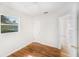 Bedroom features hardwood floors, neutral paint, ceiling fan, and natural light from one window at 5028 Oxford N Ave, St Petersburg, FL 33710