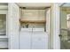 View of the laundry closet features washer and dryer and built-in shelving for storage at 5028 Oxford N Ave, St Petersburg, FL 33710