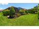 Lush backyard with manicured lawn, mature trees, and a screened-in lanai, ideal for outdoor entertaining at 5364 Salcano St, Sarasota, FL 34238
