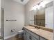 Well-lit bathroom with dark vanity, granite countertop, and large mirror offers a functional and stylish space at 5364 Salcano St, Sarasota, FL 34238