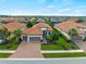 Beautiful Mediterranean-style home featuring a tile roof, three-car garage, brick driveway and lush landscaping at 5364 Salcano St, Sarasota, FL 34238