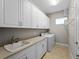Organized laundry room features ample storage, a sink, and modern appliances for efficient household tasks at 5364 Salcano St, Sarasota, FL 34238
