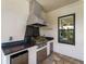 Outdoor kitchen with granite countertop, stainless steel grill, and mini-fridge on a paver patio at 5364 Salcano St, Sarasota, FL 34238