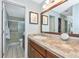 Bathroom featuring a wooden vanity, granite countertop, large framed mirror, and a tiled shower at 5417 Champagne # 63, Sarasota, FL 34235