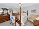 Spacious bedroom with a four-poster bed, dresser, patterned chair, and bright natural light at 5417 Champagne # 63, Sarasota, FL 34235