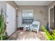 Inviting entryway featuring brick pavers, a white wicker chair, and a charming side table at 5417 Champagne # 63, Sarasota, FL 34235