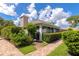 Landscaped home exterior featuring a brick walkway, manicured bushes, and a screened lanai at 5417 Champagne # 63, Sarasota, FL 34235