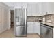 A bright kitchen features stainless steel appliances, white cabinets, and lovely stone countertops at 5417 Champagne # 63, Sarasota, FL 34235