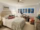 Serene bedroom with soft lighting, comfortable bedding, and a view from large windows at 555 The Esplanade N # 202, Venice, FL 34285