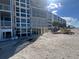 Beachfront condominium building featuring multiple floors with balconies and sand piled up outside at 555 The Esplanade N # 202, Venice, FL 34285