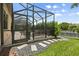 Screened in back patio with stepping stones leading out to green grass and canal views at 584 Mast Dr, Bradenton, FL 34208