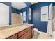 Elegant bathroom with a granite countertop, framed mirror, a shower with tile surround and crisp blue walls at 584 Mast Dr, Bradenton, FL 34208