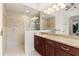 En-suite bathroom featuring a glass shower, vanity with granite countertop, and vanity mirrors at 584 Mast Dr, Bradenton, FL 34208