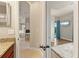 Stylish bathroom featuring granite countertops, a walk-in closet, and a doorway view into the bedroom and living area at 584 Mast Dr, Bradenton, FL 34208