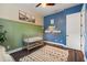Bedroom with custom green trim, designer rug, blue accent wall and modern wall shelving at 584 Mast Dr, Bradenton, FL 34208