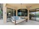 Inviting covered patio with a porch swing, adjacent to the screened-in swimming pool and outdoor seating area at 584 Mast Dr, Bradenton, FL 34208