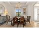 Formal dining room with decorative chandelier and large window with sheer curtains at 584 Mast Dr, Bradenton, FL 34208