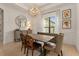 Elegant dining room features a modern light fixture and a wooden table, complemented by natural light from the window at 584 Mast Dr, Bradenton, FL 34208