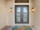 Elegant front door with glass inserts and sidelights, complemented by stylish outdoor lighting at 584 Mast Dr, Bradenton, FL 34208