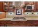 Close up of kitchen with gas cooktop, custom backsplash, and stainless steel vent hood at 584 Mast Dr, Bradenton, FL 34208