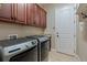 Laundry room with dark wood cabinets and modern washer and dryer units at 584 Mast Dr, Bradenton, FL 34208
