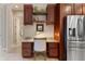 Kitchen office nook features built in shelves, granite counters, and stainless fridge at 584 Mast Dr, Bradenton, FL 34208