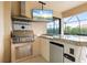 Outdoor kitchen features stainless steel grill, mini-fridge, and a granite countertop bar area at 584 Mast Dr, Bradenton, FL 34208