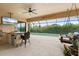 Outdoor kitchen boasts a bar, ceiling fan, grill, and mounted TV near the screened-in pool and outdoor seating at 584 Mast Dr, Bradenton, FL 34208