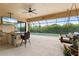 Covered outdoor living area with TV, grill, bar seating, and a view of the refreshing pool at 584 Mast Dr, Bradenton, FL 34208