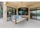 Covered patio featuring a cozy swing bed, offering a relaxing view of the backyard and pool at 584 Mast Dr, Bradenton, FL 34208