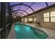 Evening view of the screened-in pool and spa with a covered patio and outdoor dining area at 584 Mast Dr, Bradenton, FL 34208