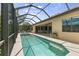 Daytime view of the screened-in pool and spa with a covered patio and outdoor dining area at 584 Mast Dr, Bradenton, FL 34208