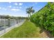Backyard showcasing grass area, lush landscaping and canal views at 584 Mast Dr, Bradenton, FL 34208