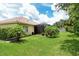 Exterior view of home highlighting screened in patio and lush tropical landscape in a spacious backyard at 6214 45Th E Ln, Bradenton, FL 34203