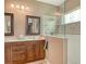 Bright bathroom featuring double vanity, decorative mirrors, and glass-enclosed shower for a luxurious experience at 6214 45Th E Ln, Bradenton, FL 34203