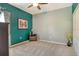 Cozy bedroom featuring two-tone walls, neutral carpeting, a ceiling fan, and simple furnishings at 6214 45Th E Ln, Bradenton, FL 34203