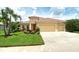 Charming single-story home featuring a red tile roof, well-manicured lawn, and a two-car garage at 6214 45Th E Ln, Bradenton, FL 34203