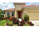 Inviting front entrance with a red door and lush landscaping creating a warm curb appeal at 6214 45Th E Ln, Bradenton, FL 34203
