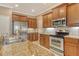 Modern kitchen featuring stainless steel appliances, granite countertops, and wood cabinetry at 6214 45Th E Ln, Bradenton, FL 34203